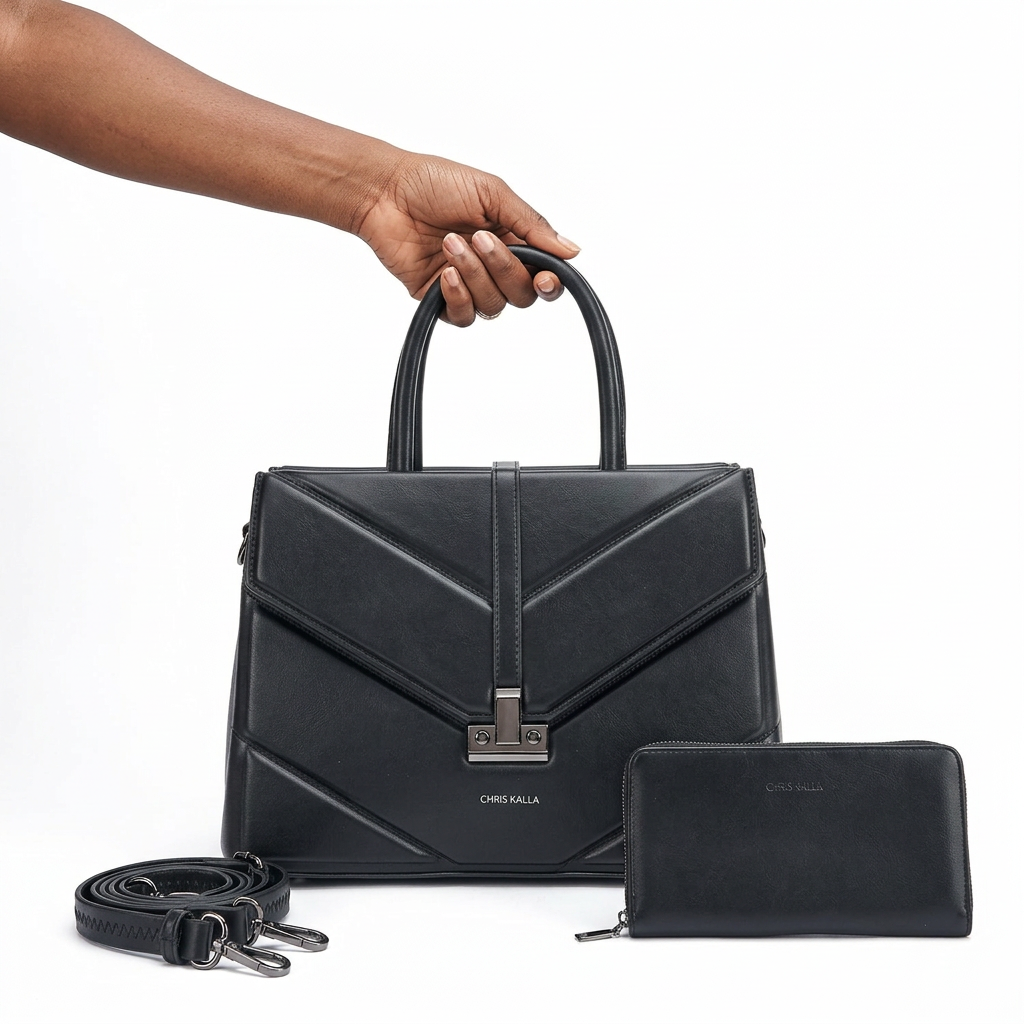 Black woman’s hand holding a black handbag with matching pouch and strap