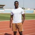 Black Nigerian male model wearing brown premium sport shorts with white jersey on running track