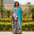 Nigerian female model wearing turquoise panel novelty print bubu kaftan in garden setting