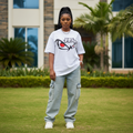 Nigerian female model wearing white angry eyes mascot graphic oversized tee – front view