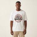 Model wearing white varsity emblem graphic T-shirt