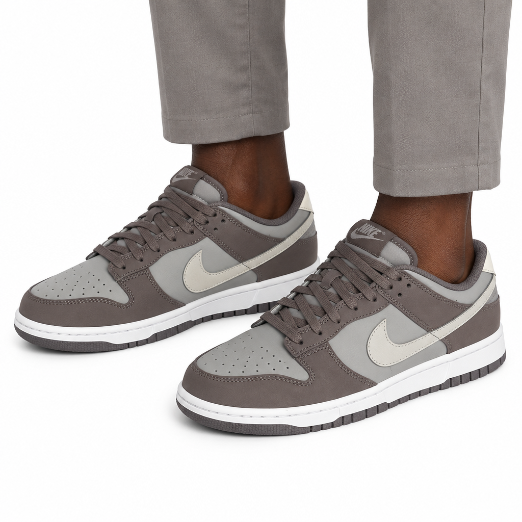Man wearing grey-taupe low-top sneakers, both feet visible
