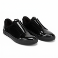 Pair of black slip-ons with glossy toe caps and matte side panels on white