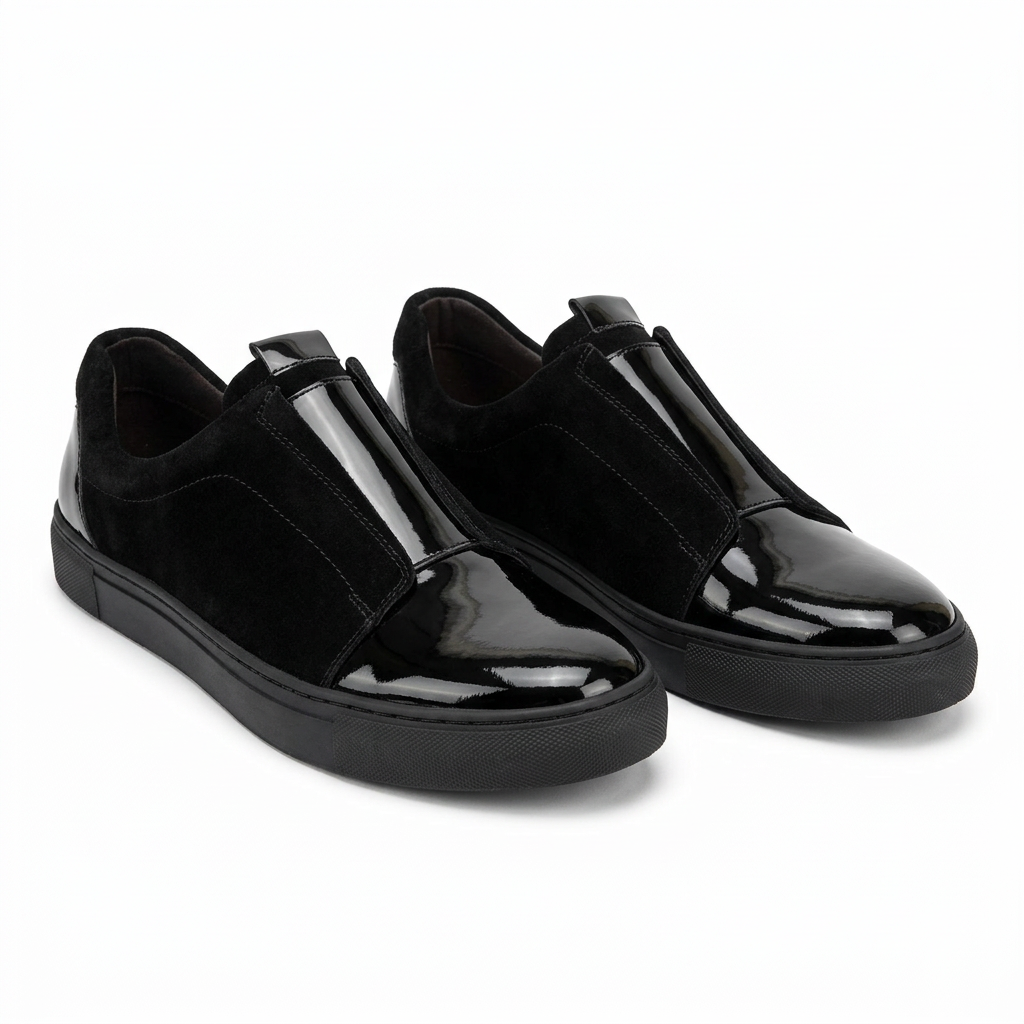 Pair of black slip-ons with glossy toe caps and matte side panels on white