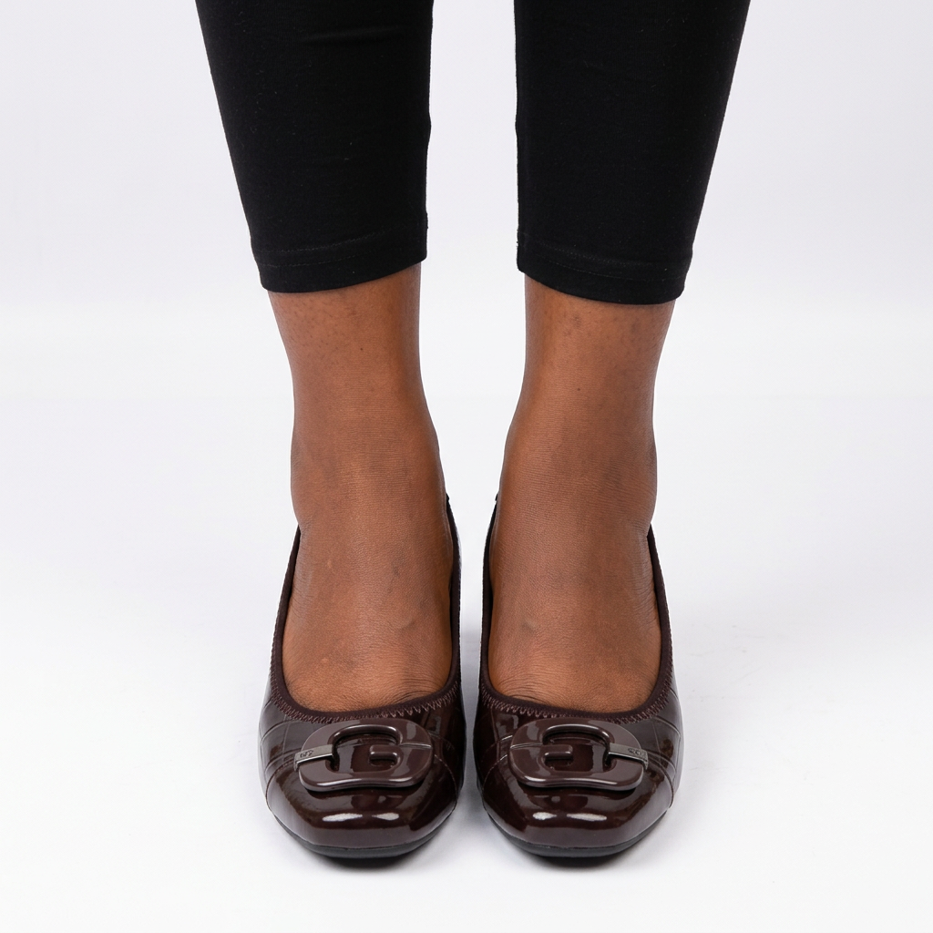 Adult woman wearing burgundy-brown tab wedges with feet together