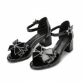 Ghost mannequin pair view of black patent leather block heel sandals with rhinestone bow detail, left and right shoe
