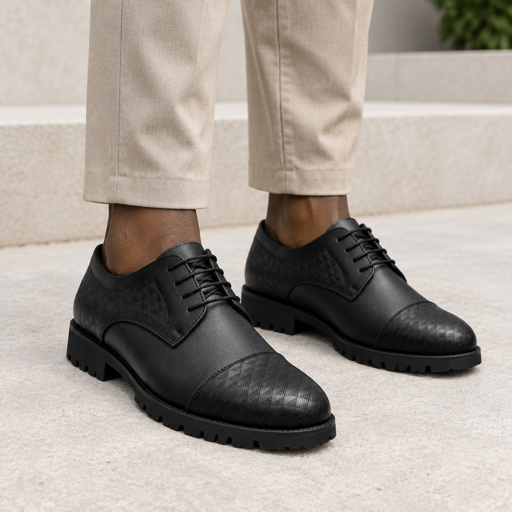 Black model wearing black men's textured cap-toe lace-up shoes