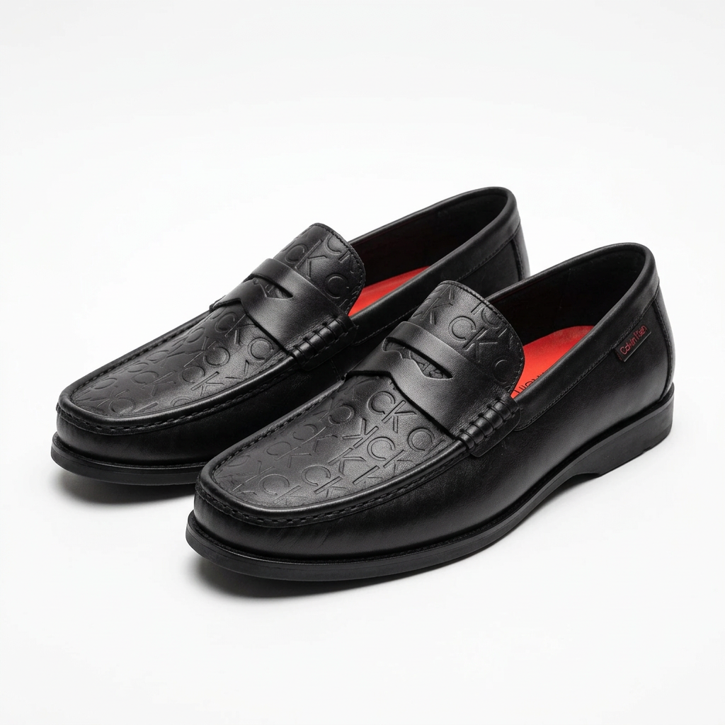 Pair of black embossed penny loafers with red footbeds on white