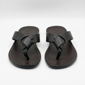 Pair of black knotted toe-post slides with brown stitched footbeds on white