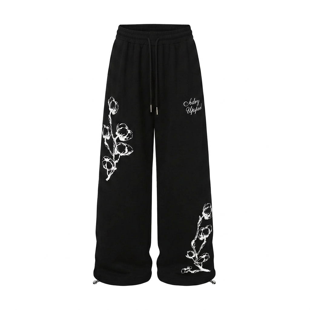 Black wide-leg drawstring trousers with contrasting white floral graphics