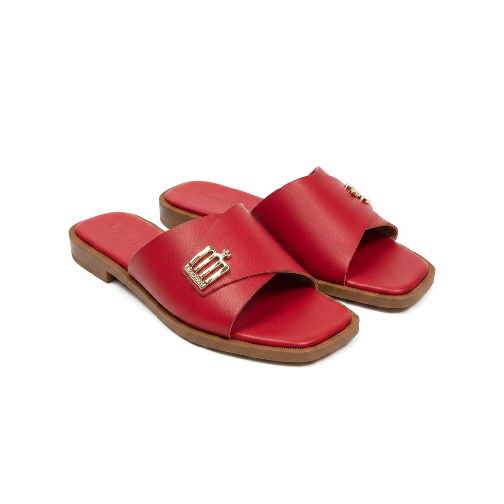 Pair of red leather wide strap flat slide slippers with gold logo hardware on white background