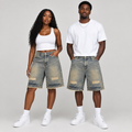 Woman and man wearing longer faded grey-blue distressed denim shorts together