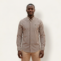 Male model wearing a brown and ivory striped long-sleeve shirt against a plain off-white background