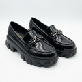 Matching black glossy chain-accent chunky loafers standing together
