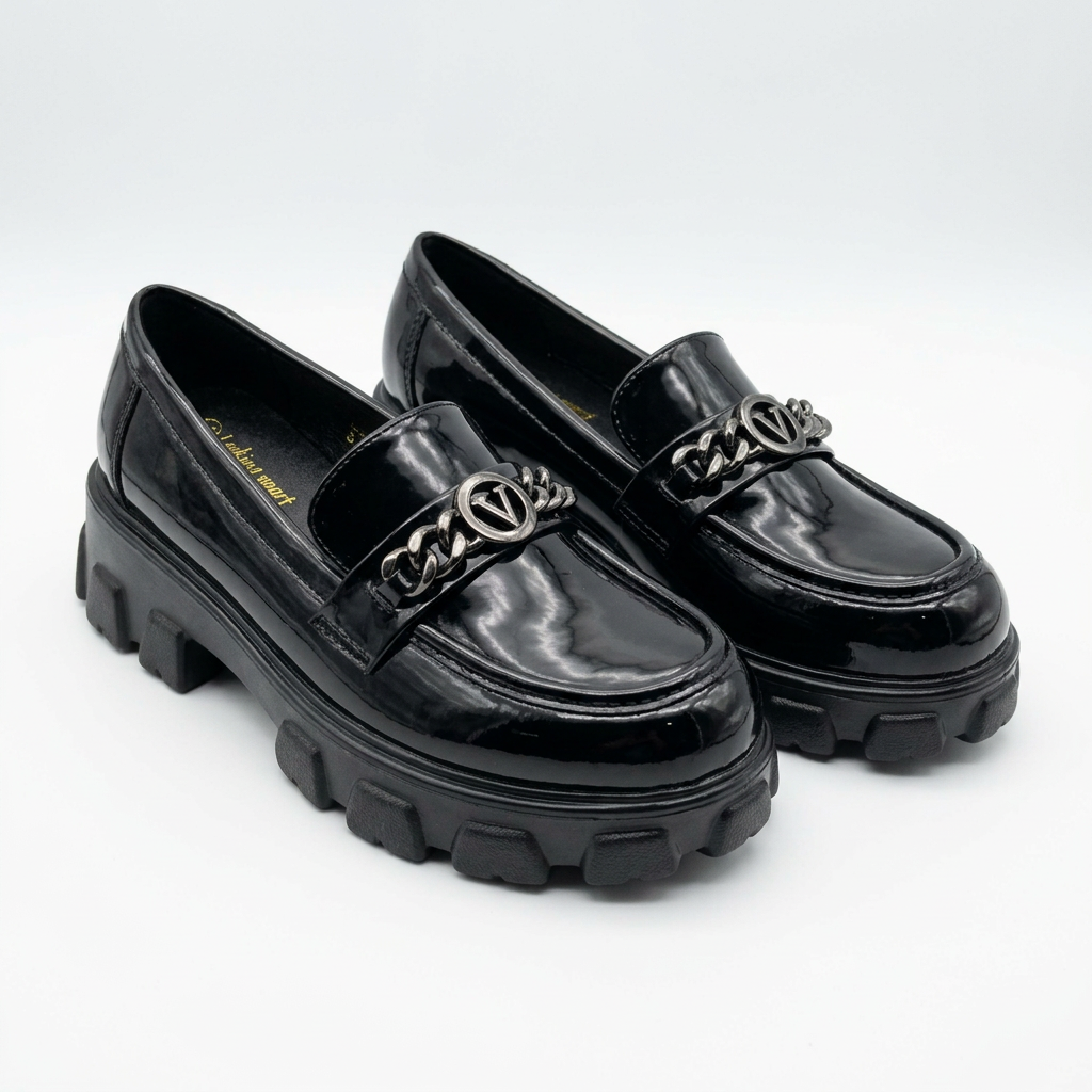 Matching black glossy chain-accent chunky loafers standing together