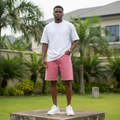 Nigerian male model wearing men's dusty rose pink wide-leg denim shorts streetwear style