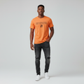 Young Nigerian male wearing bold orange Uptown The Museum Wash DC graphic crew neck tee