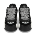 Front view of black chunky sneakers with black-and-white patterned laces