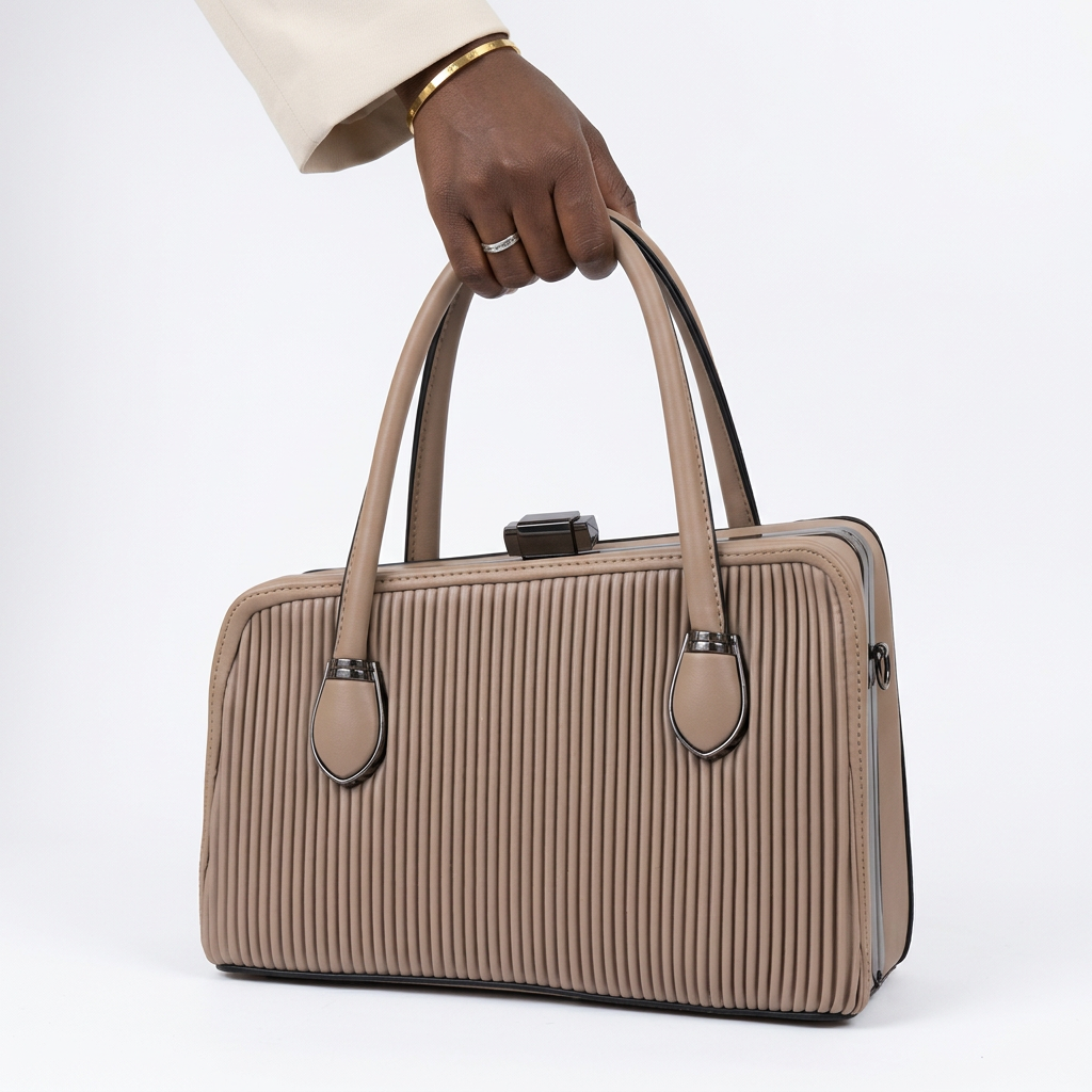 Black adult woman’s hand holding a taupe ribbed handbag on a plain white background