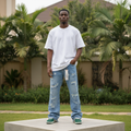 Nigerian male model wearing light blue heavily distressed straight-leg jeans – full body lifestyle shot