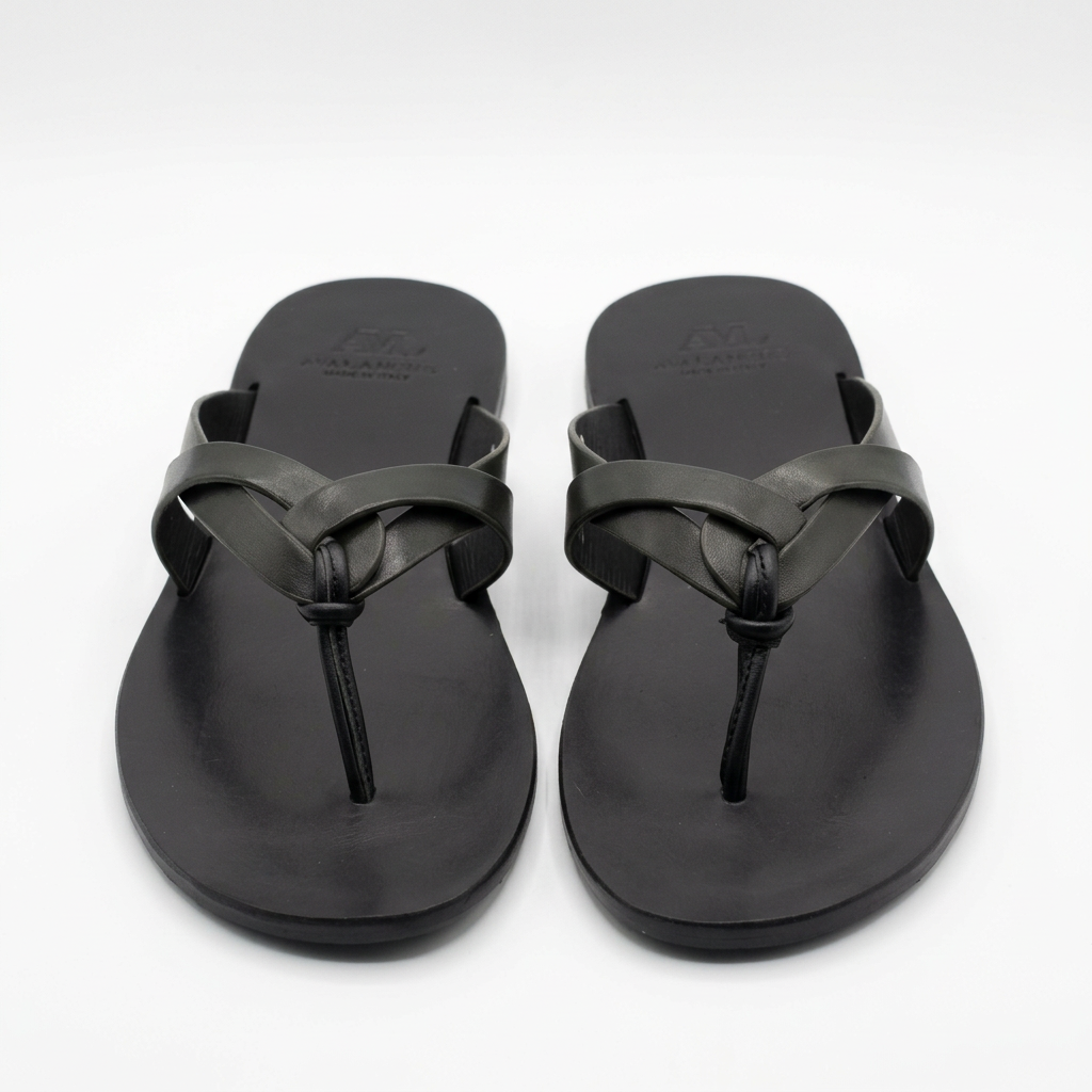 Pair of black overlap-strap toe-post slides on white