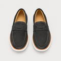 Pair of dark charcoal suede loafers with tan trim and white soles