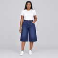 Female model wearing dark indigo wide-leg denim long shorts