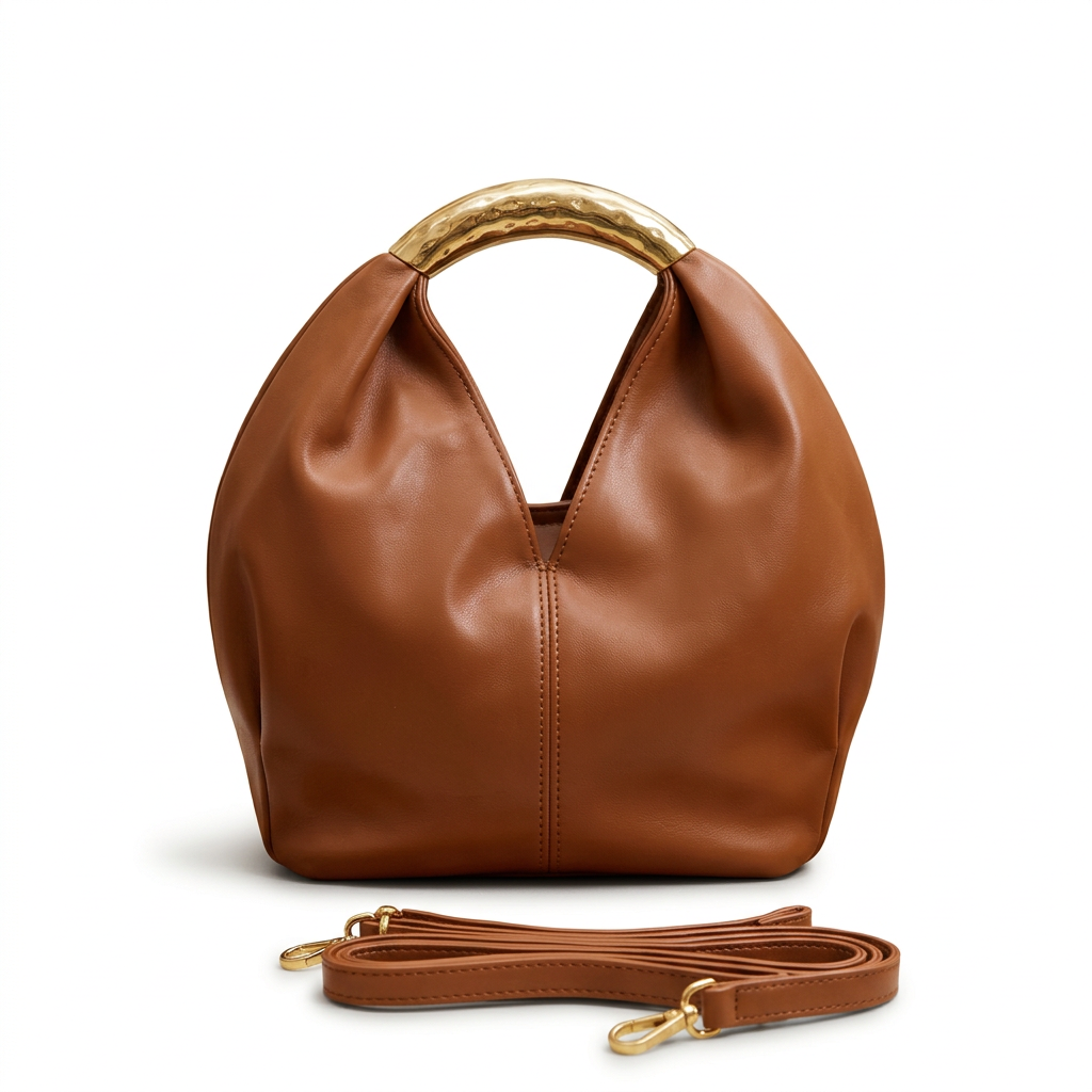 Warm-brown rounded handbag without label with gold-tone handle and matching strap on white
