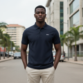 Young Nigerian male model wearing dark navy polo shirt, front view, Nigerian urban background
