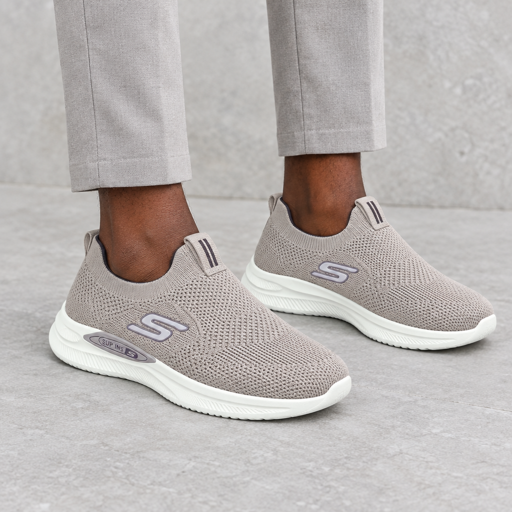 Taupe knit slip-on sneakers worn on both feet