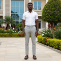 Nigerian male model wearing brown perforated leather horsebit loafer shoes in garden setting