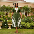 Nigerian female model wearing olive green and white lace border pleated midi gown in upscale garden setting
