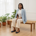 Nigerian female model seated wearing navy croc-embossed patent ballet flats with square metal buckle detail