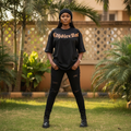 Nigerian female model wearing black copper gothic calligraphy arch graphic oversized tee – front view