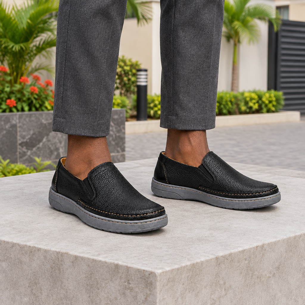 Man wearing black pebble grain slip-on loafers with charcoal trousers