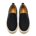 Straight-on black green-trim slip-on sneakers with cream ribbed soles