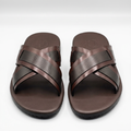 Pair of brown slides with dark perforated cross straps on white