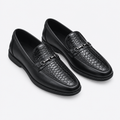 Black men's embossed-texture buckle loafers shown as a complete pair