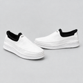 Men's white slip-on sneakers with black collar, front and side view