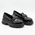 Complete pair of black glossy chain-detail chunky loafers resting on a white floor