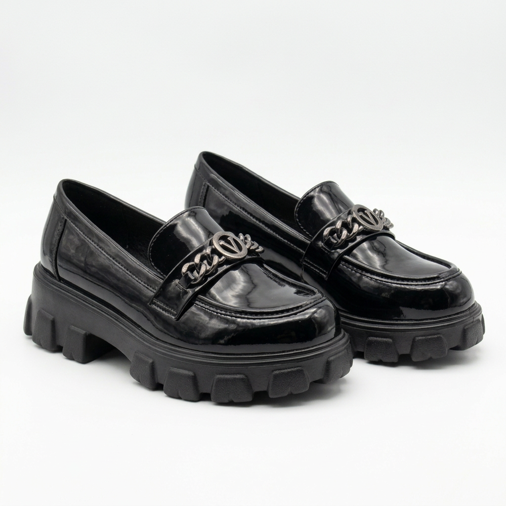 Complete pair of black glossy chain-detail chunky loafers resting on a white floor