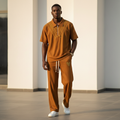 Male model wearing cognac gold chevron ribbed polo and trouser two-piece set