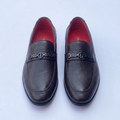 Straight-on black textured loafers with geometric hardware and red lining