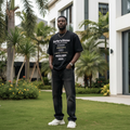 Nigerian male model wearing black white stacked text graphic tee – front view