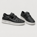 Black perforated double-strap shoes with textured uppers and white soles