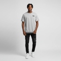 Young Nigerian male wearing light grey NY Jets striped hem graphic tee
