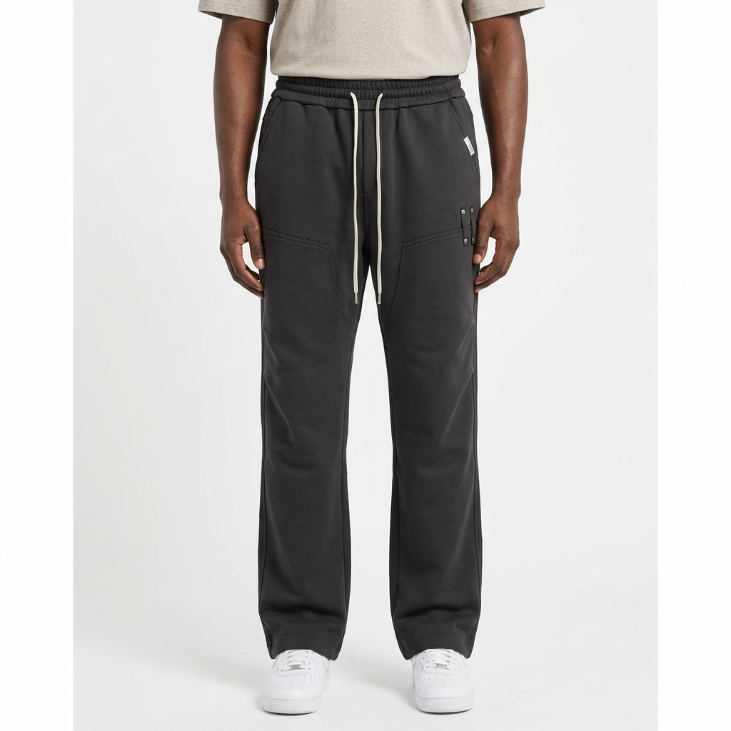 Adult Black model wearing charcoal grey straight-leg joggers with white drawstrings and metal accents