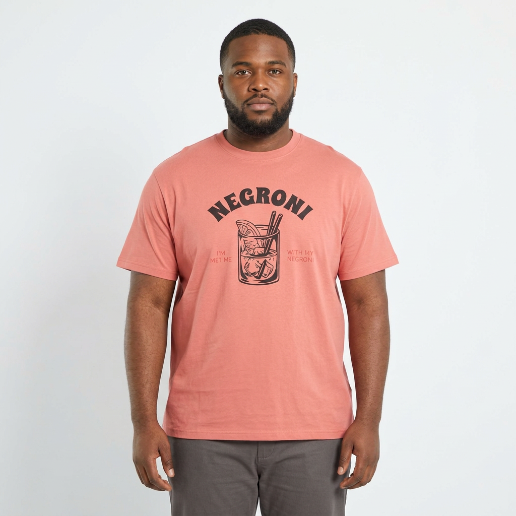 Full-head view of a Black adult male model wearing the coral pink graphic T-shirt