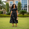 Nigerian female model wearing Women's Black Rhinestone Peplum Top & Printed Pleated Midi Skirt Set