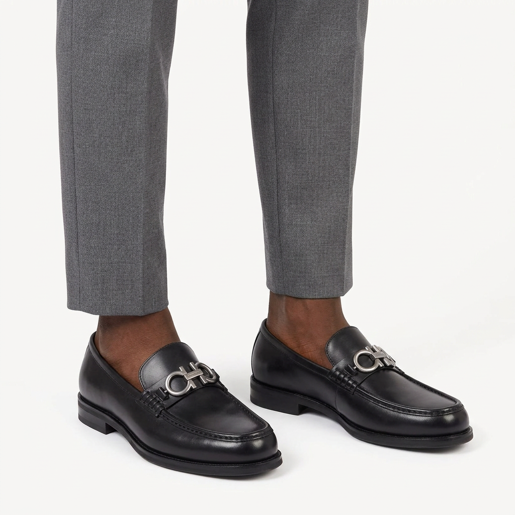 Black silver-loop loafers properly worn on both feet with grey trousers